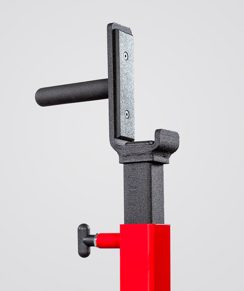 Close-up of a mechanical component with a red base and black handle on a light gray background