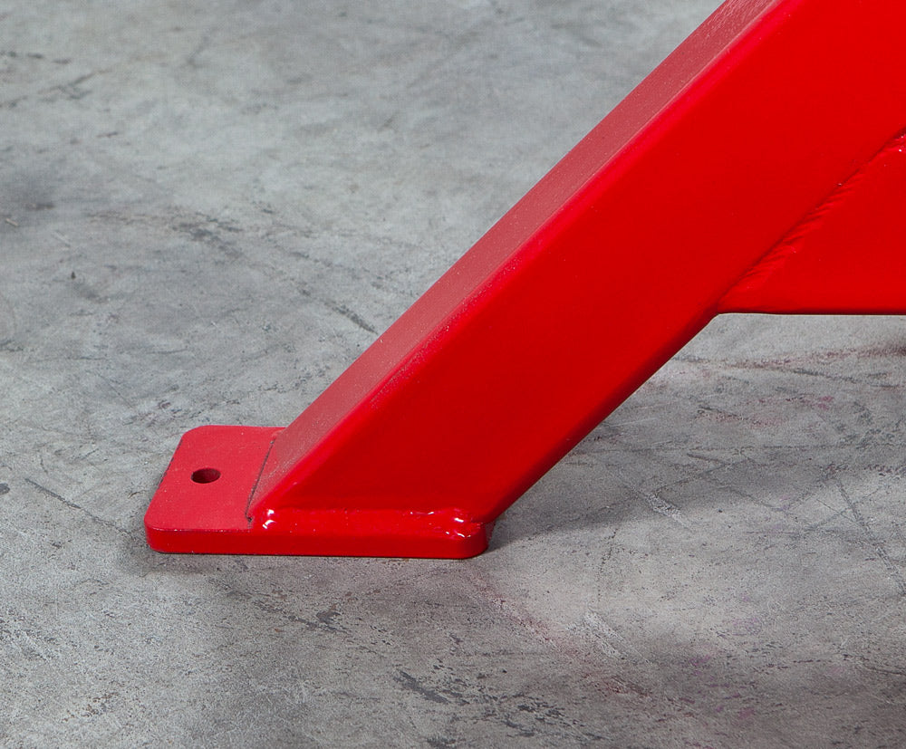 Red metal bracket on a gray concrete floor
