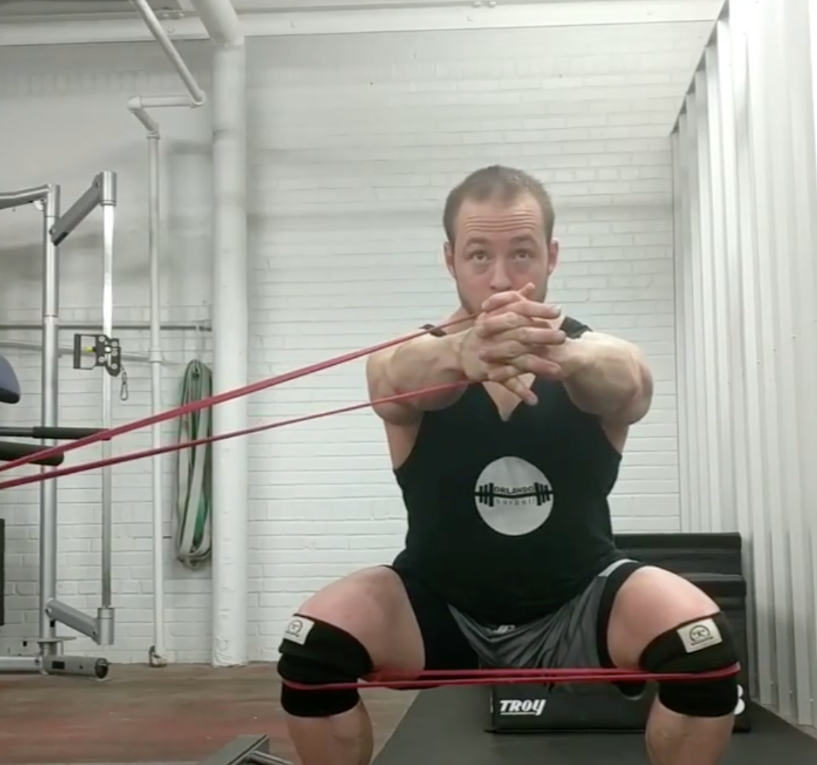 Man exercising with resistance bands in a gym setting